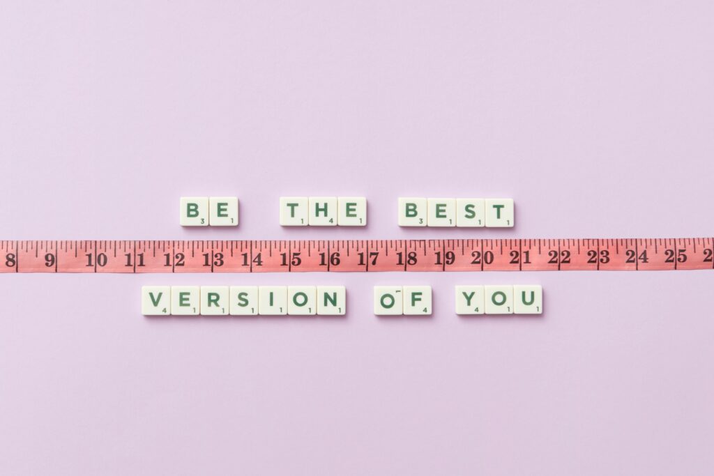 Motivational phrase 'Be the Best Version of You' with a measuring tape on purple background.